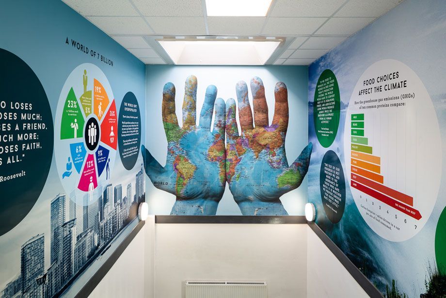 A room with a mural of two hands painted on the wall.