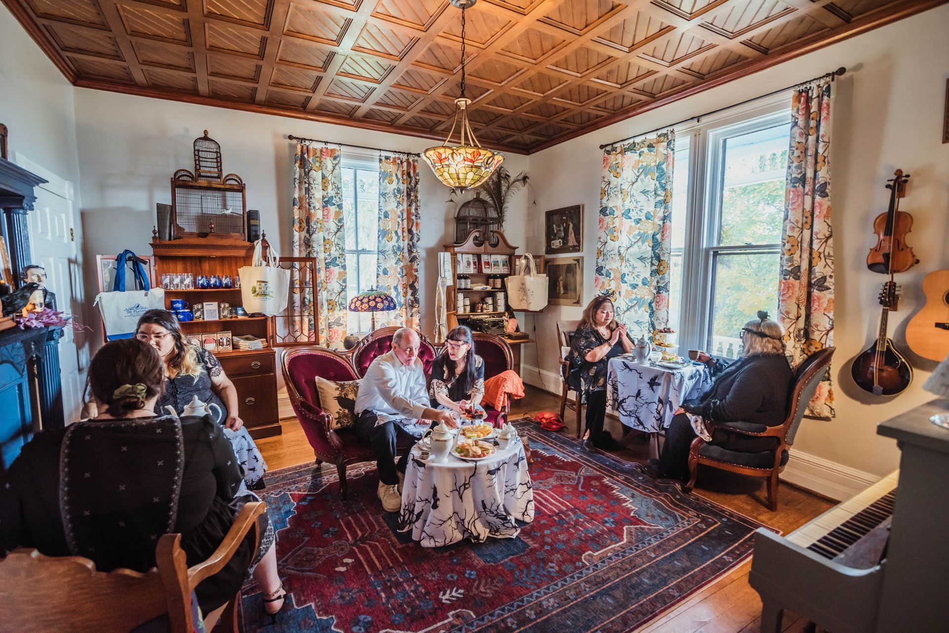 A group of people are sitting at tables in a living room.