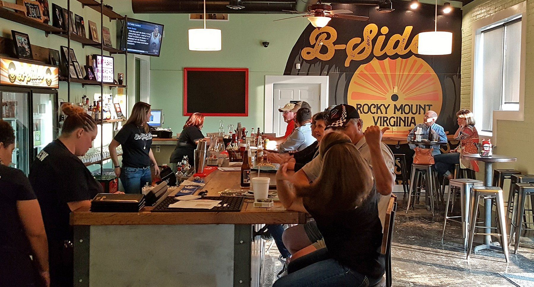 A group of people are sitting at tables in a restaurant.