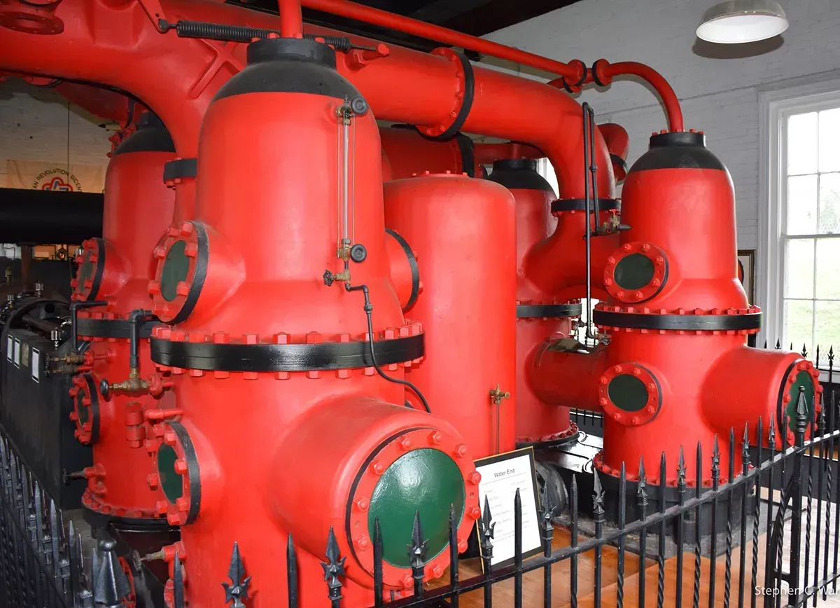A bunch of red pipes are sitting next to each other in a room.