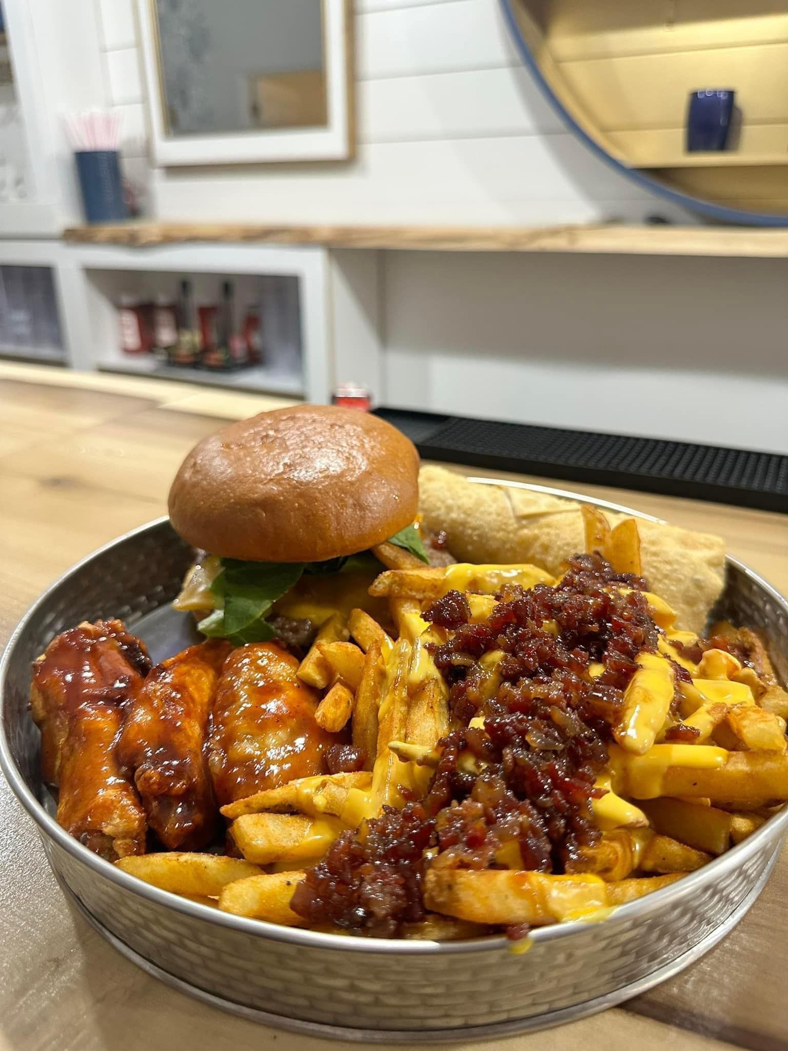 A plate of food with a hamburger and french fries on a table.