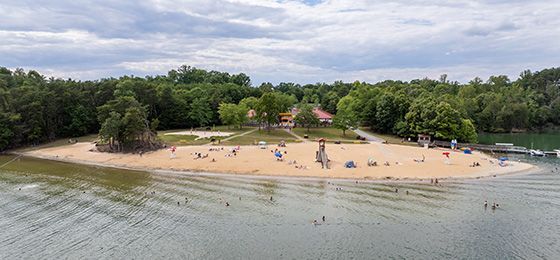 An aerial view of a beach surrounded by water and trees.