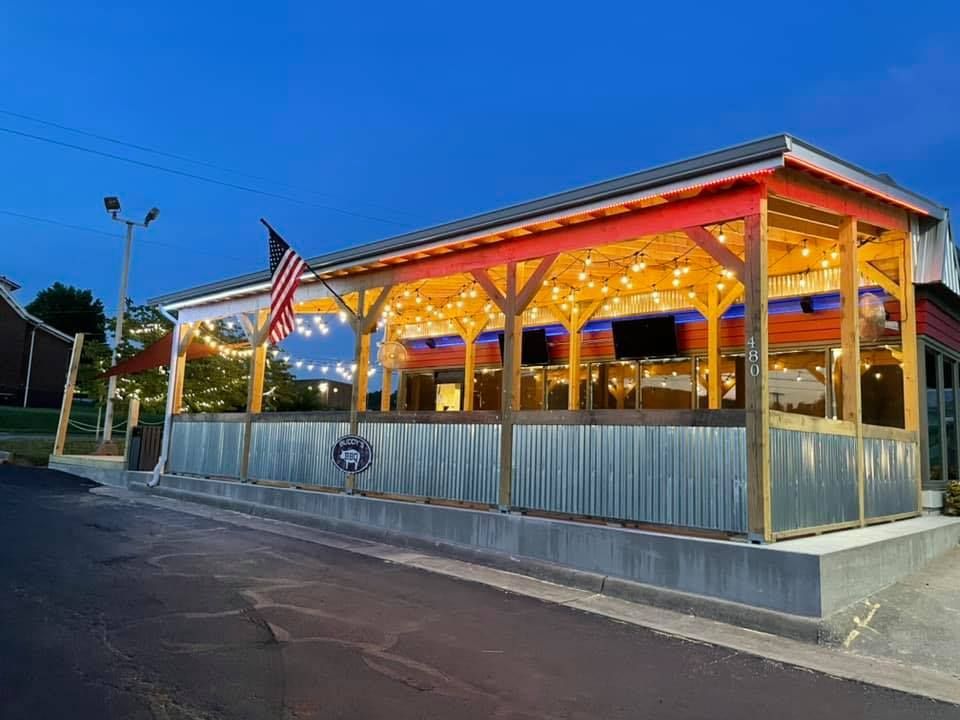 A large building with a red , white and blue awning and an american flag.