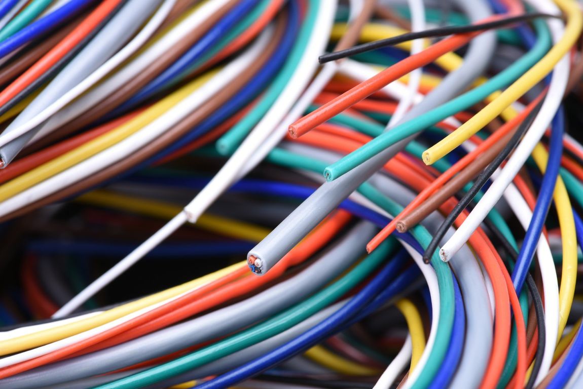 Un fascio di fili elettrici colorati e aggrovigliati, visto da vicino.