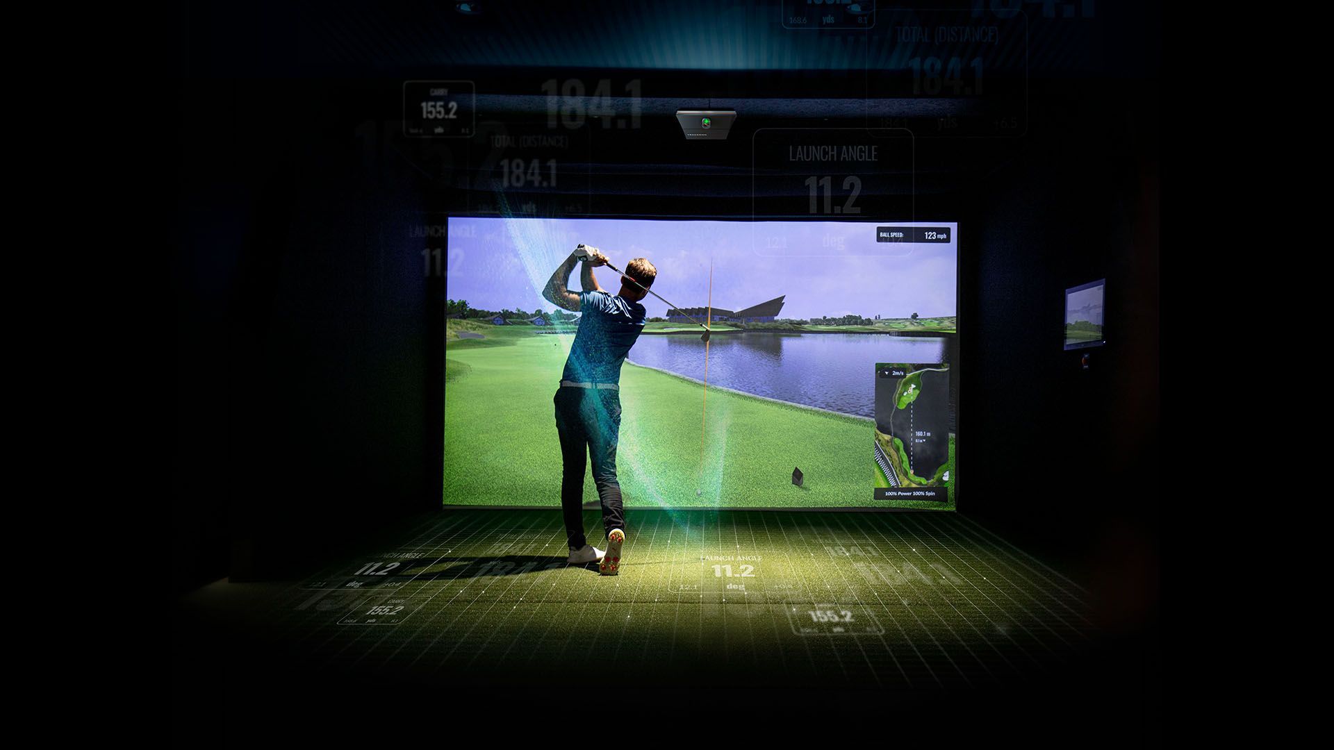 A man is playing a video game of golf in a dark room.