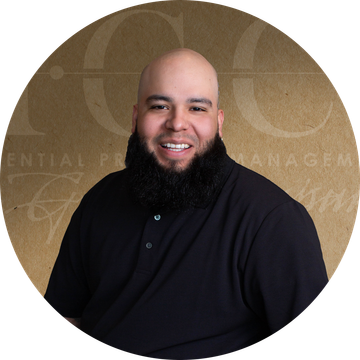A man with a beard in a black shirt smiles.