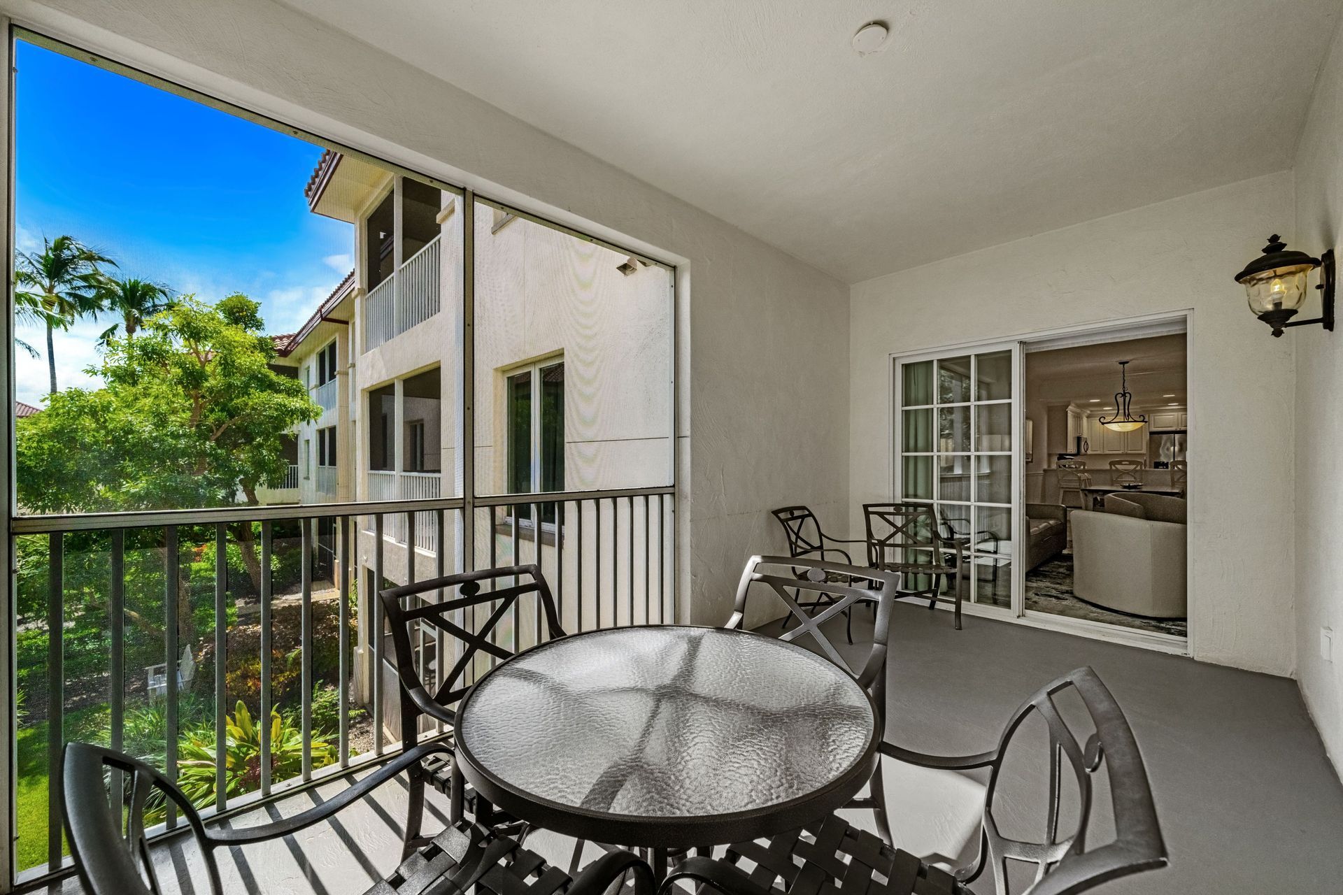 Balcony with patio table and chairs overlooking neighboring buildings and greenery