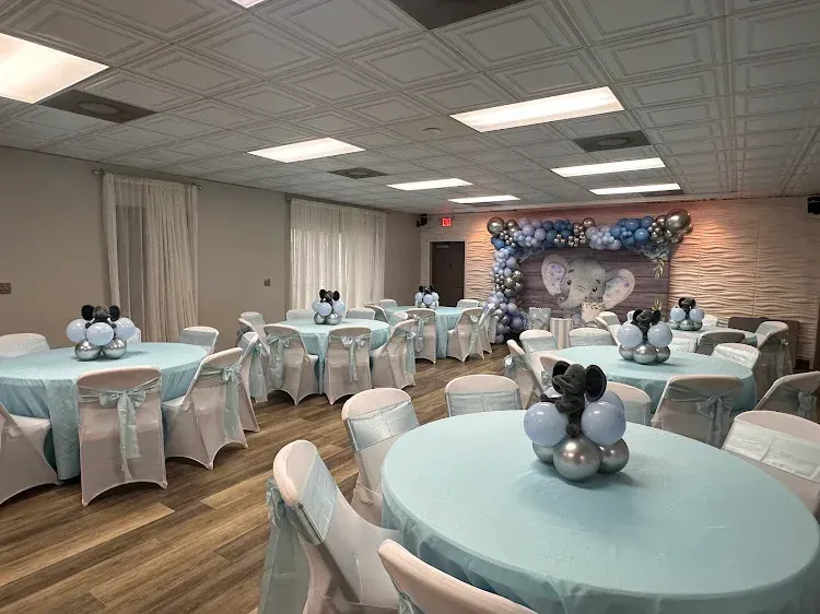 Event room decorated with blue and silver balloons and table settings.