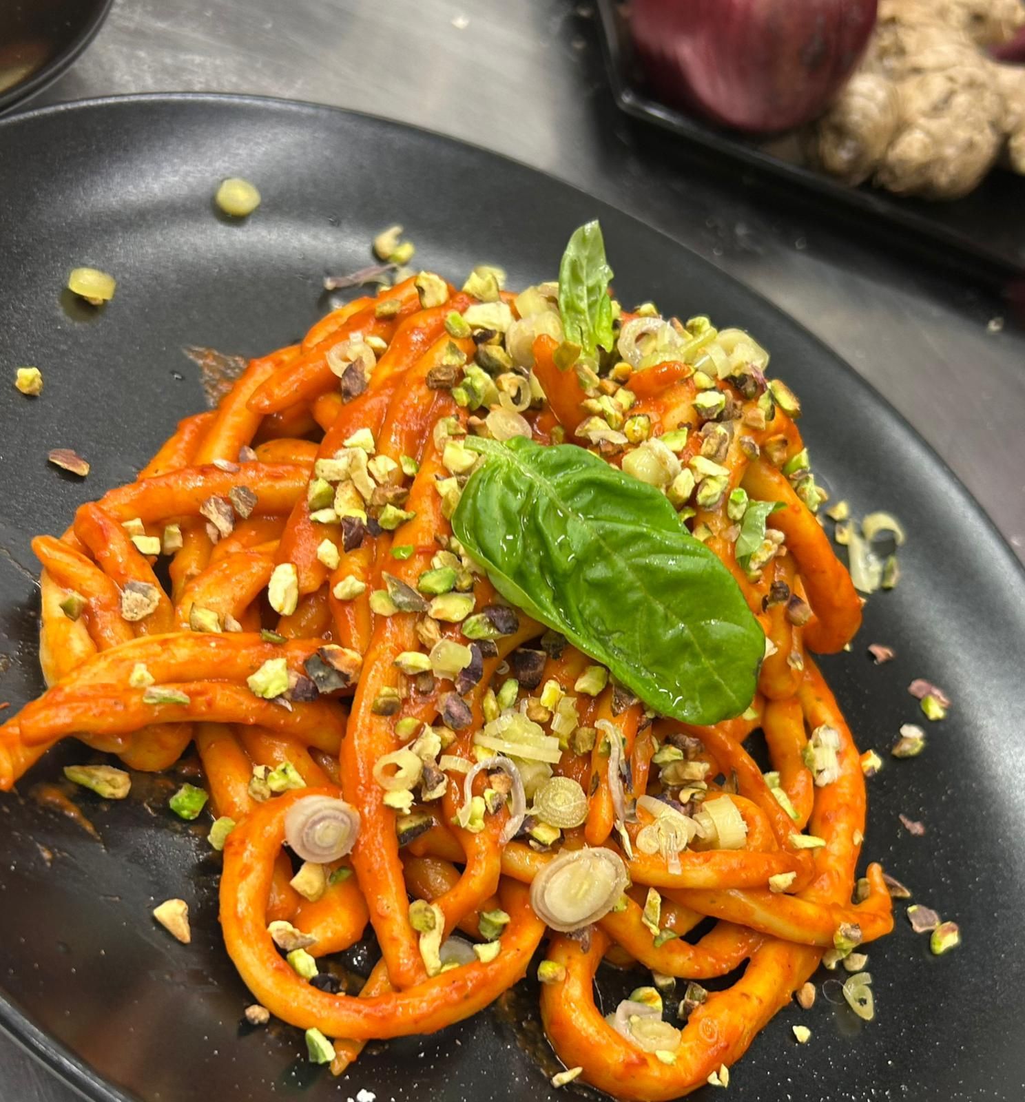 Una ciotola di coloratissimi spaghetti fritti e verdure su un tavolo scuro