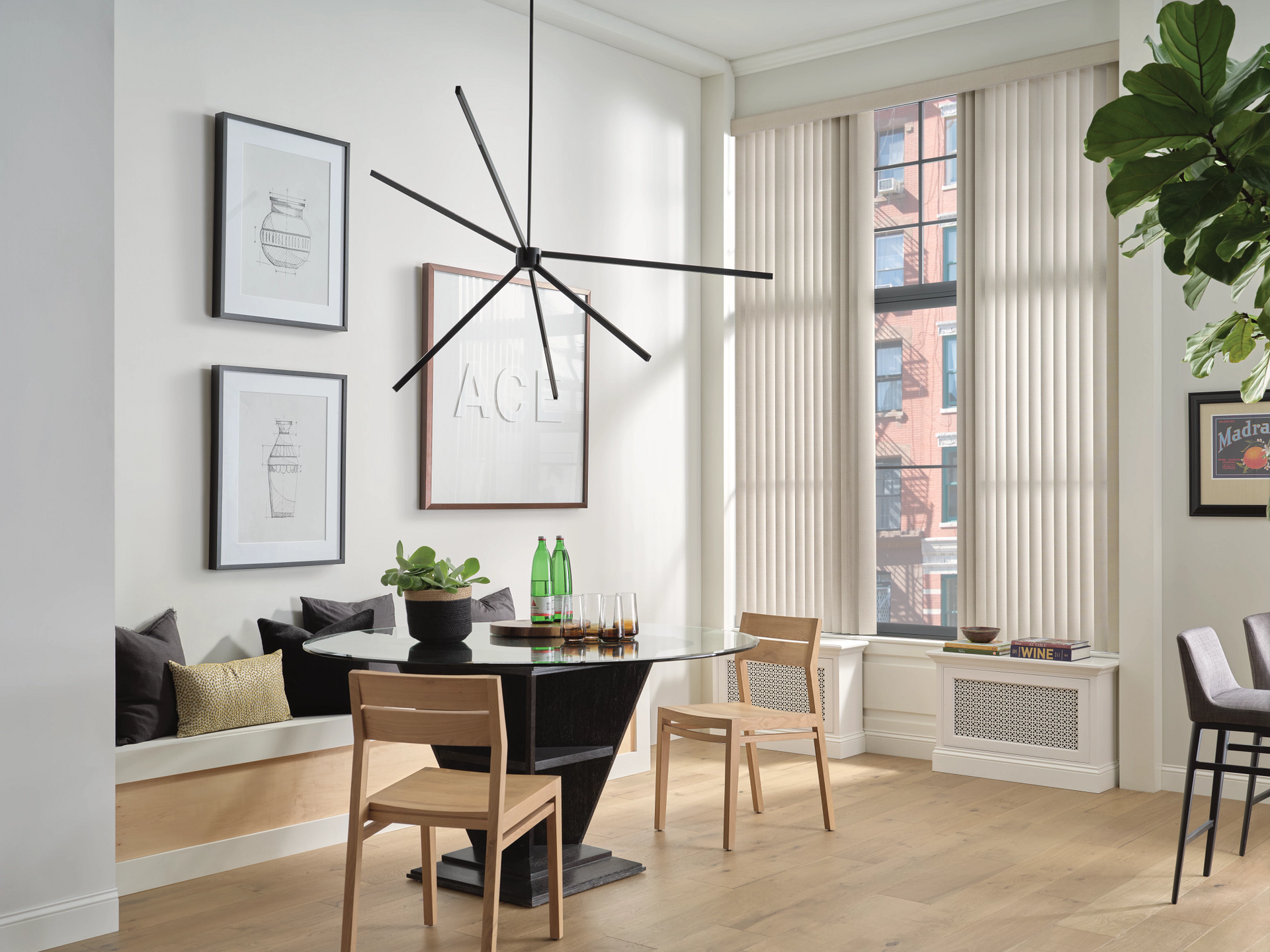 Bright modern dining room with black table, wooden chairs, large window, and hanging geometric chandelier