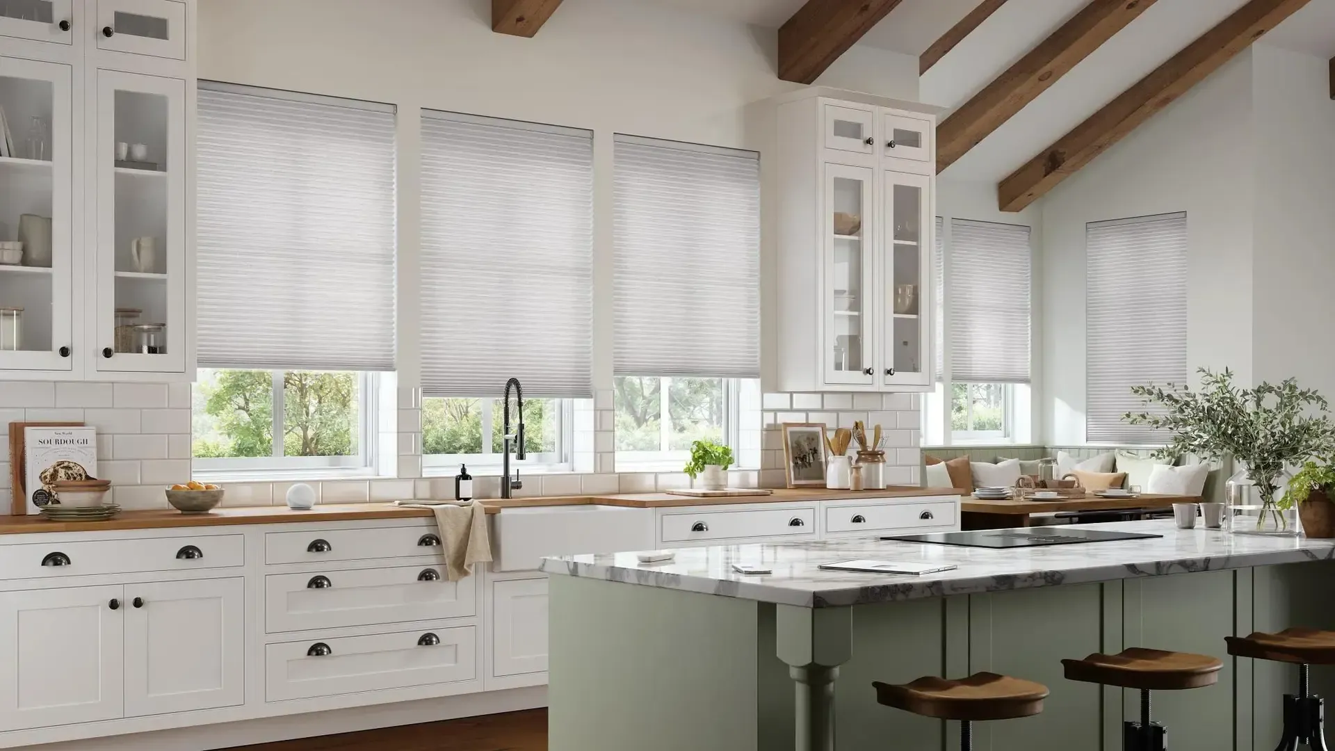 Bright white farmhouse kitchen with large windows, island, and green stools