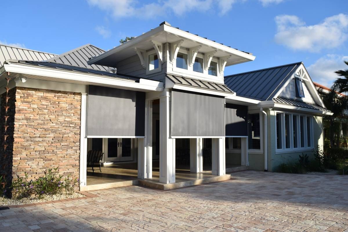 Retractable Fenetex hurricane shades partially extended over a covered patio entrance.