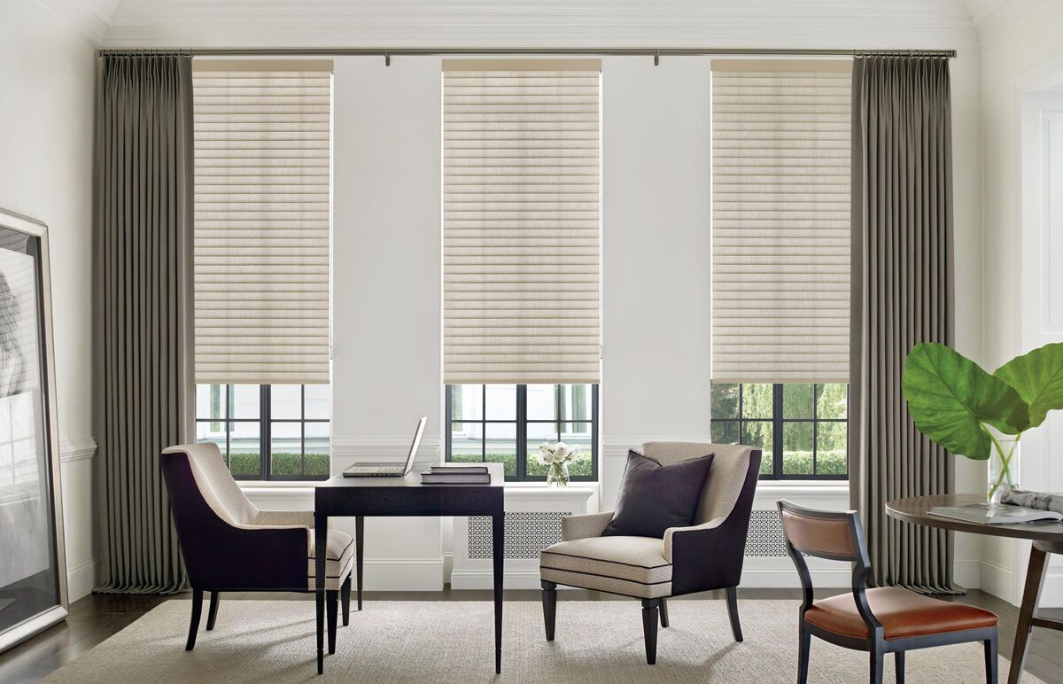 Elegant home office with desk, two chairs, large windows, beige blinds, and a potted plant