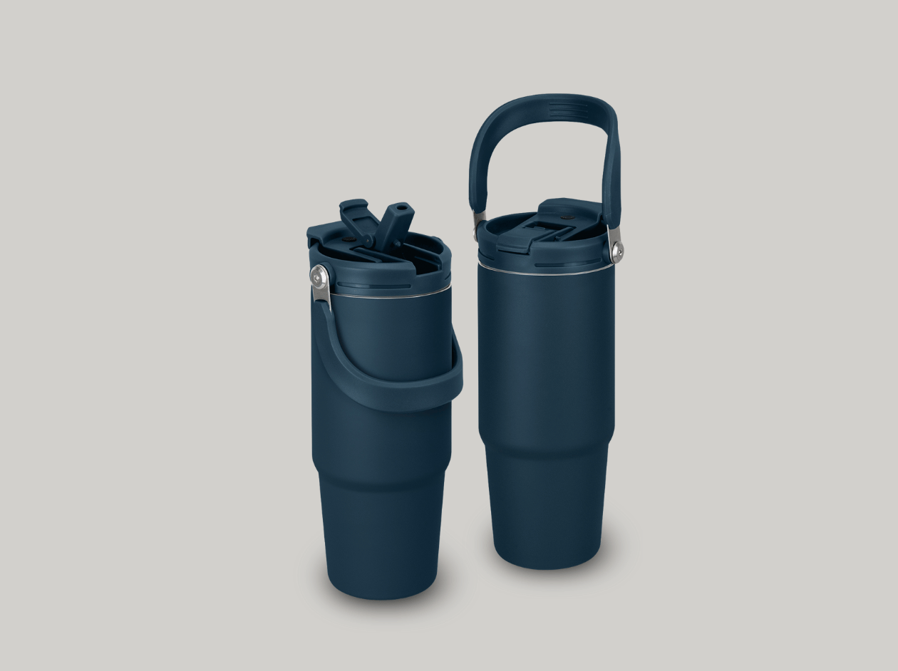 Two dark blue travel mugs, one open with a lid and one with a handle, on a light background
