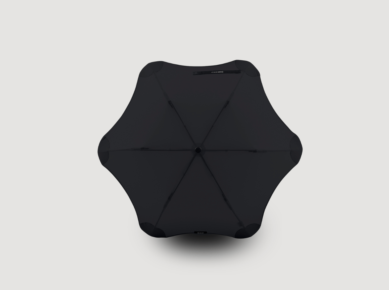 Black geometric foldable stool or ottoman on a light gray background