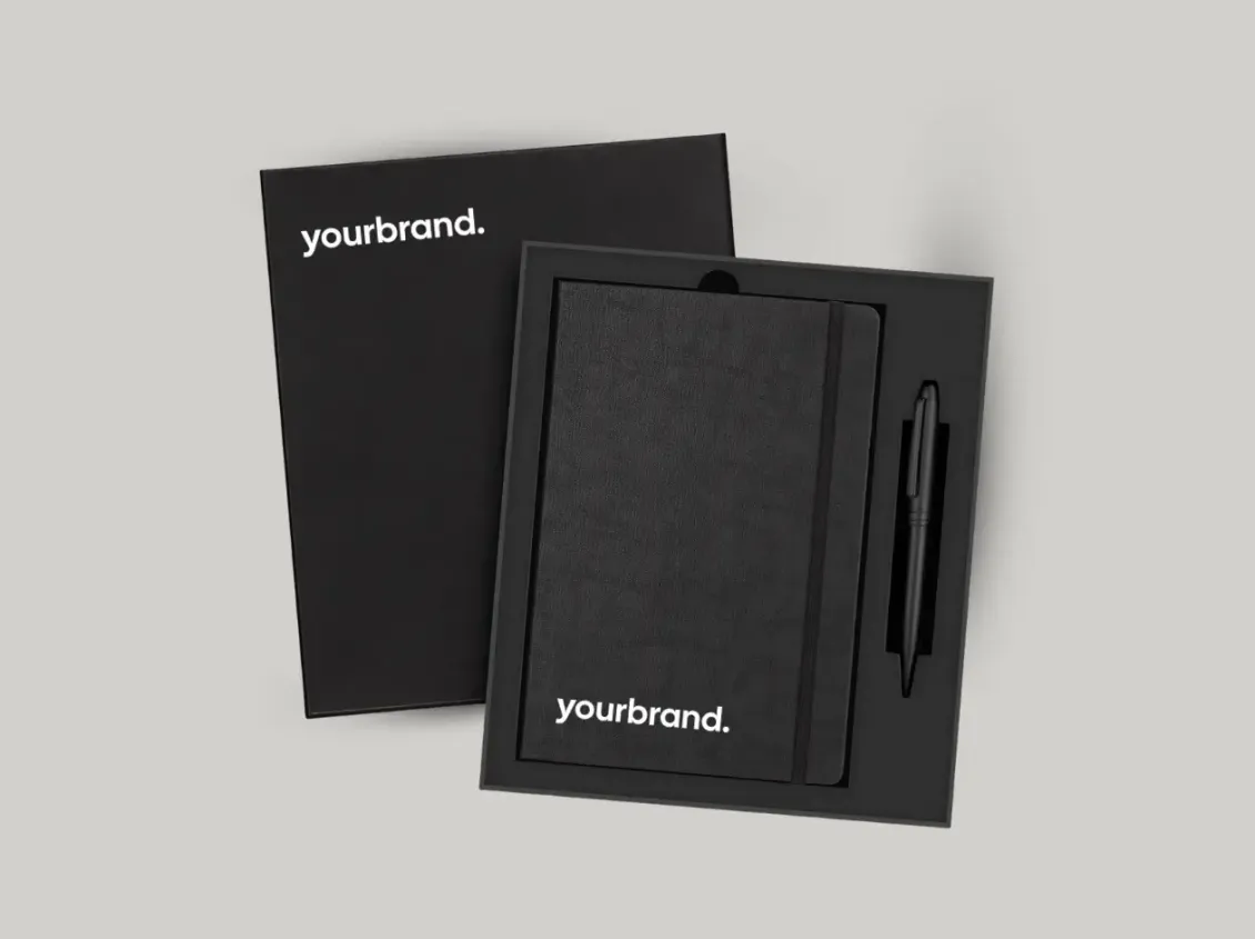 Black branded notebook and matching pen with “yourbrand” text on a light background