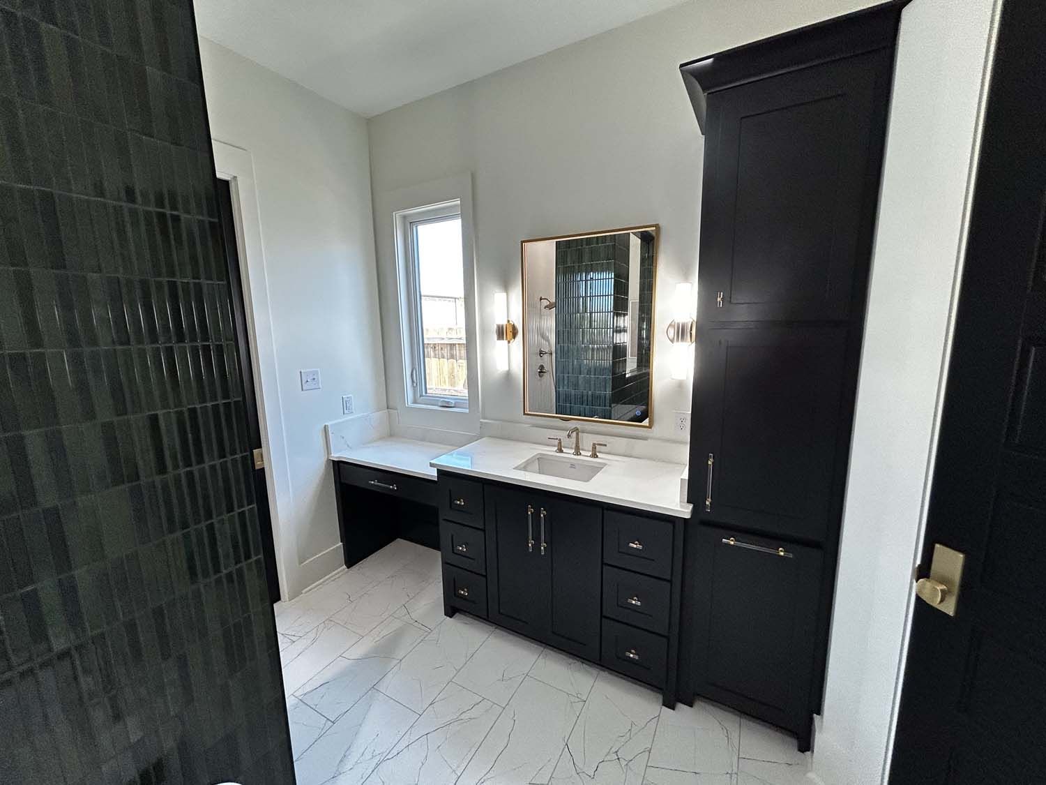 Bathroom with black vanity and tall cabinet, white countertop and tile floor, and a window.