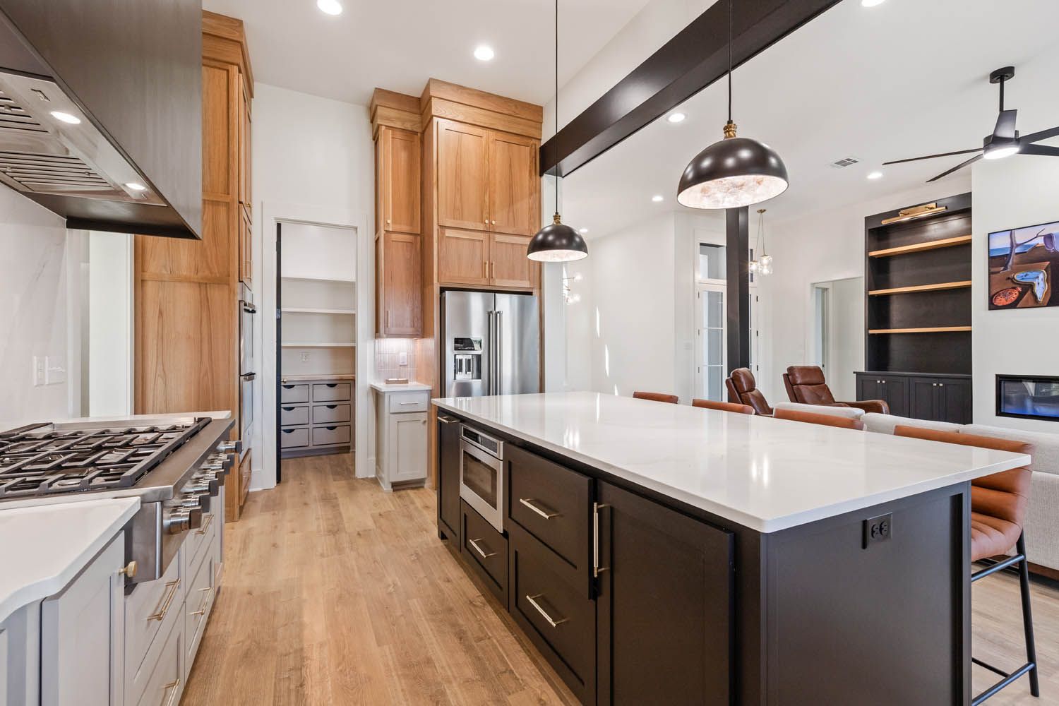 Modern kitchen with island, stainless steel appliances, and wood cabinets.