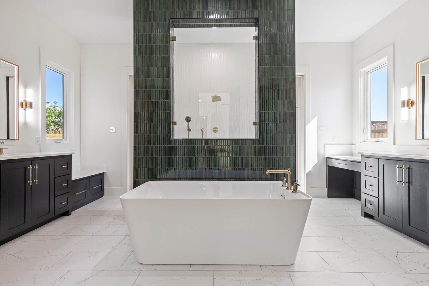 A modern bathroom with white tub, dark green tile accent wall, and dark gray cabinets.