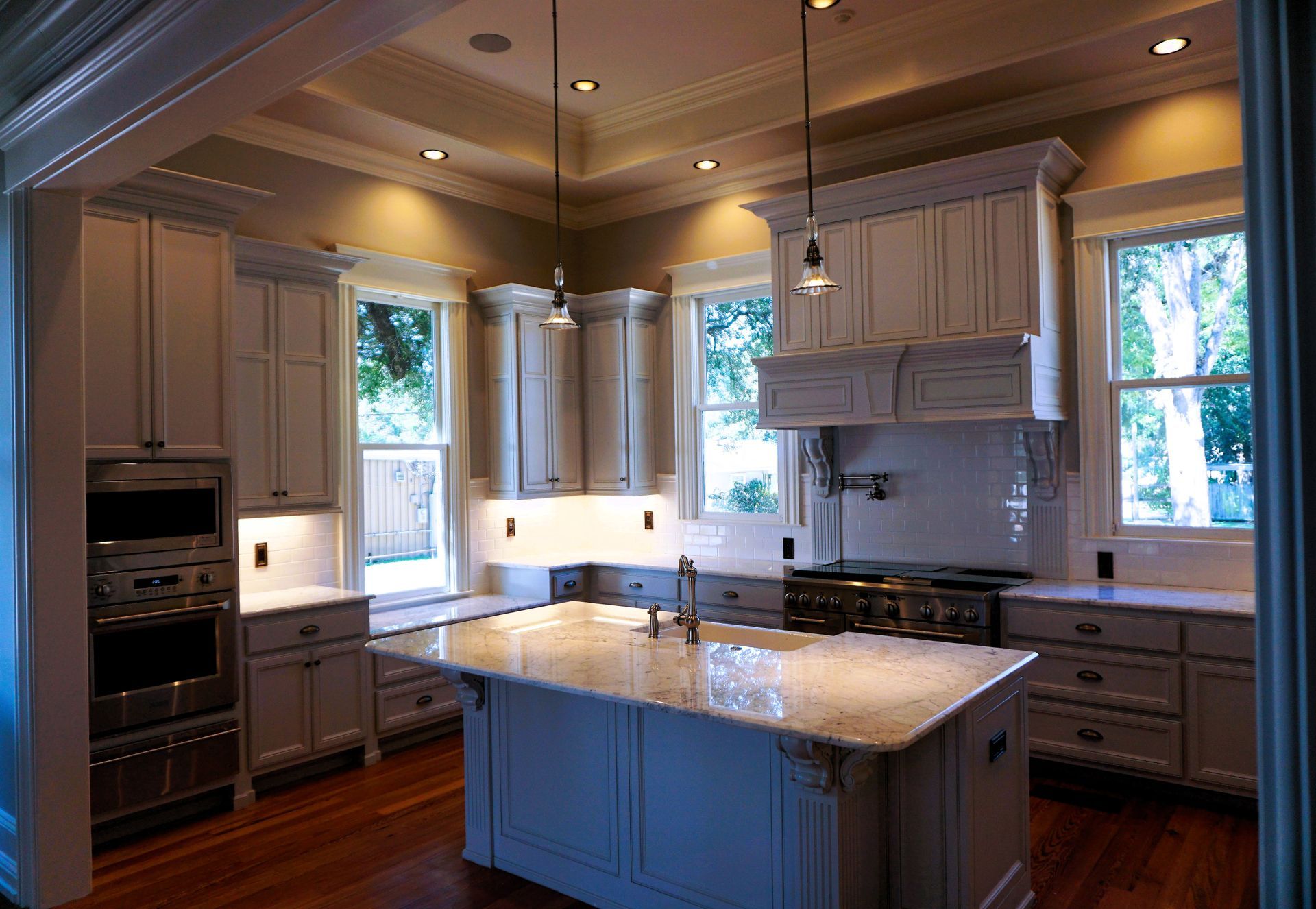 Elegant kitchen with light-colored cabinets, a granite island, and a stainless steel oven.