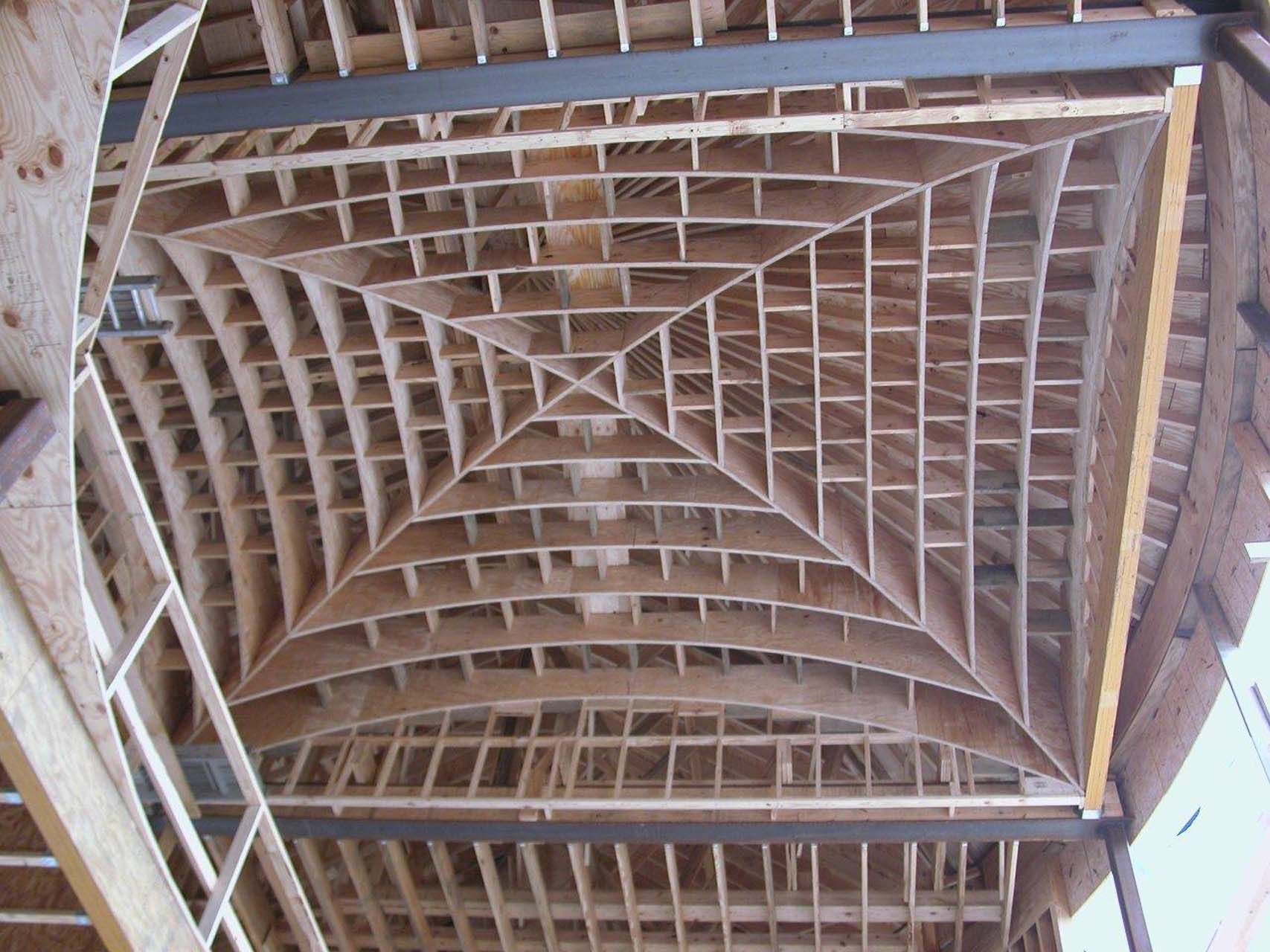 Wooden ceiling under construction, with a geometric, grid-like pattern.