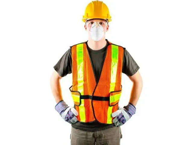 Un hombre que lleva un casco y un chaleco de seguridad está de pie con las manos en las caderas.