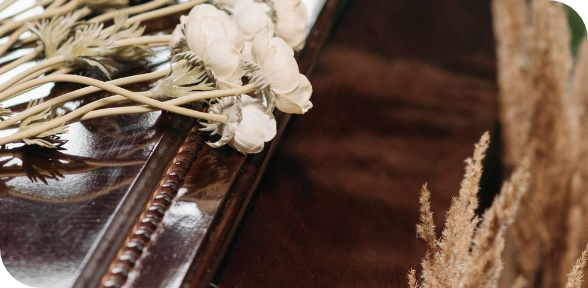 Dried flowers beside a wooden tray on a cozy brown tabletop