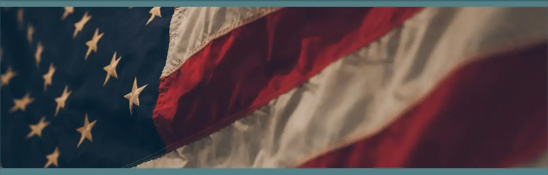 Close-up of the American flag waving, showing stars and red-and-white stripes.