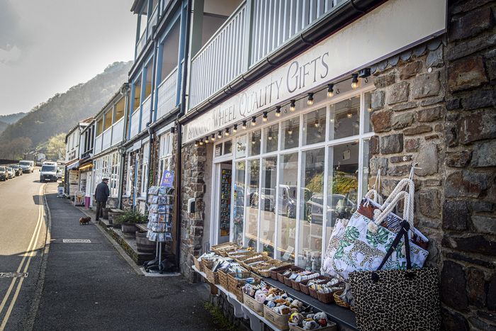 Side view of Spinning Wheel Quality gift shop, with baskets filled with toys outside the property.