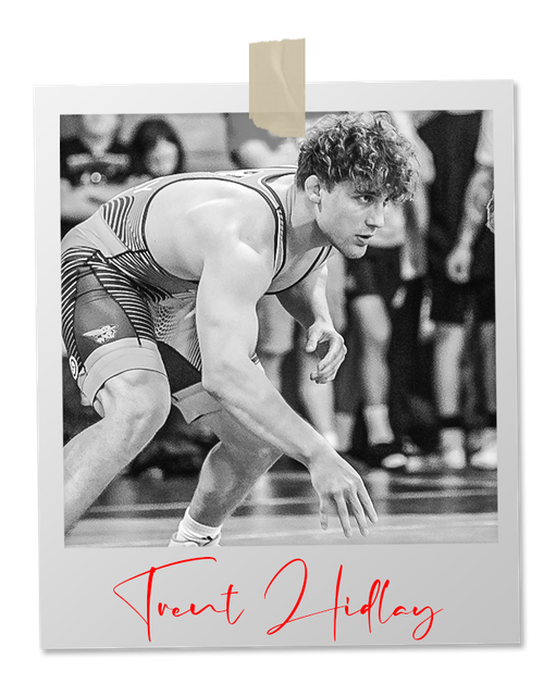 A black and white photo of a wrestler in an "NC State" singlet. Signature below reads "Trent Hidlay"
