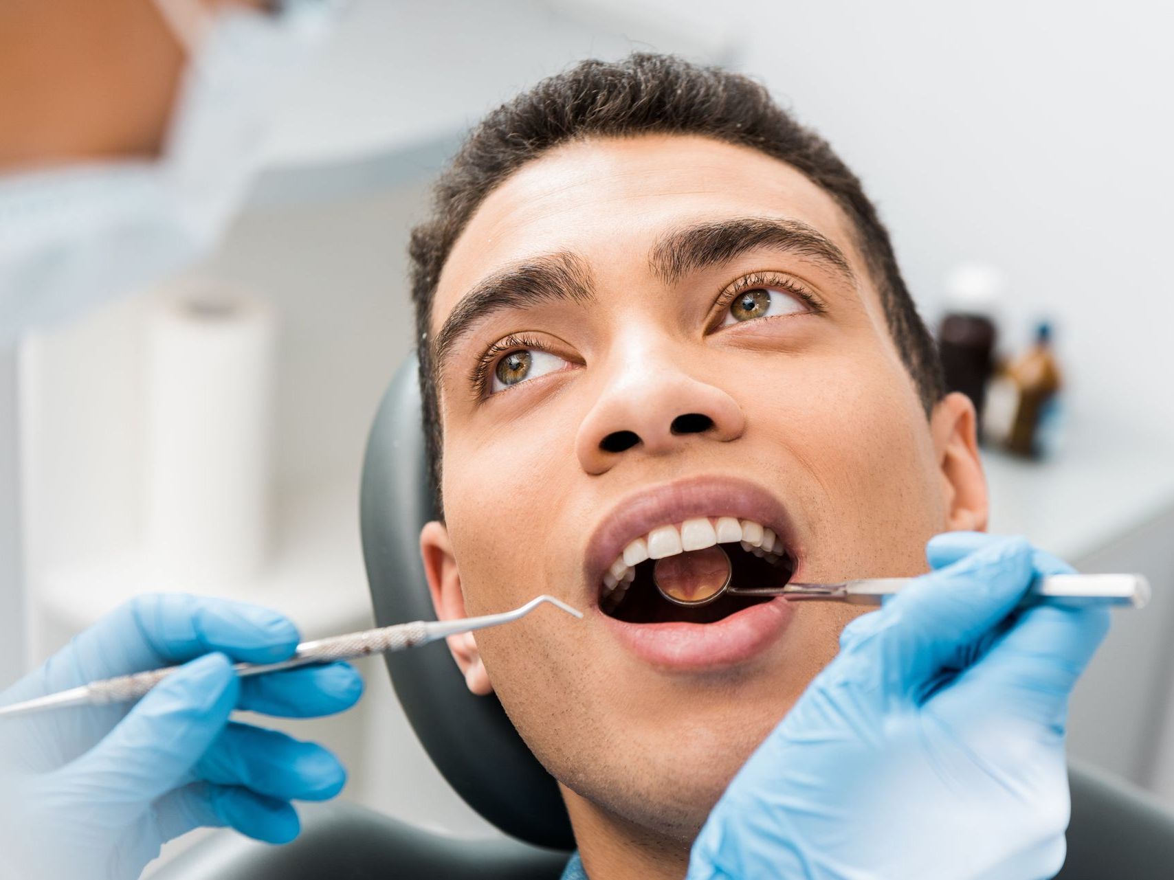 A man is getting his teeth examined by a dentist