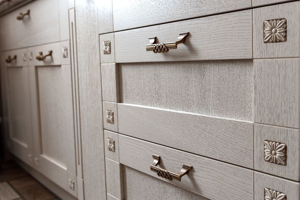 A Kitchen With White Cabinets and Drawers With Gold Handles — Wardrobe World In Paget, QLD