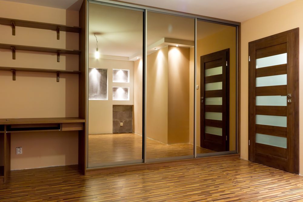 An Empty Room With a Sliding Glass Door and a Desk — Wardrobe World In Paget, QLD
