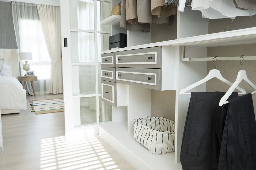 A Walk in Closet With a Sliding Glass Door Leading to a Bedroom — Wardrobe World In Paget, QLD