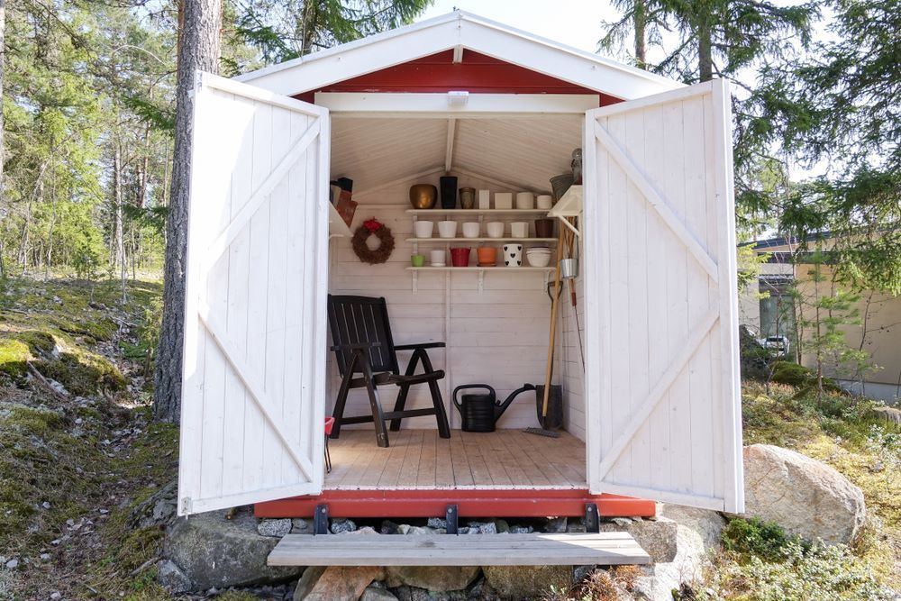 A White Shed With a Red Roof and a Chair in It — Wardrobe World In Paget, QLD