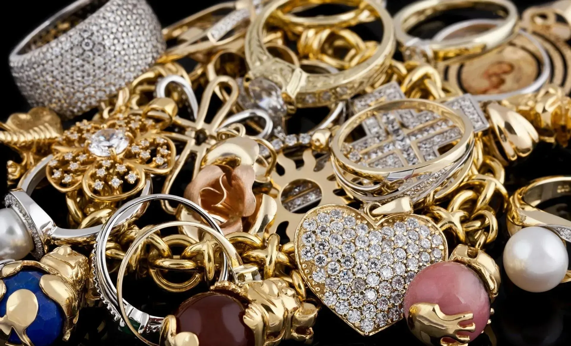 A pile of gold jewelry on a black surface.