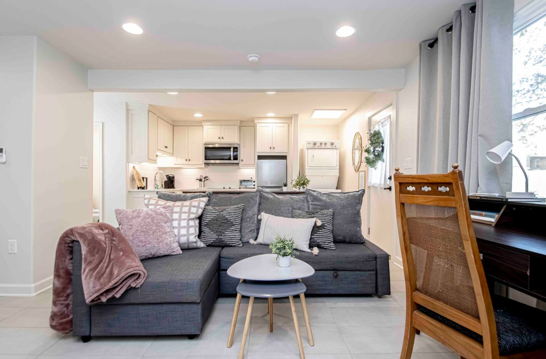 Gray sectional sofa in living area with kitchen visible in the background.