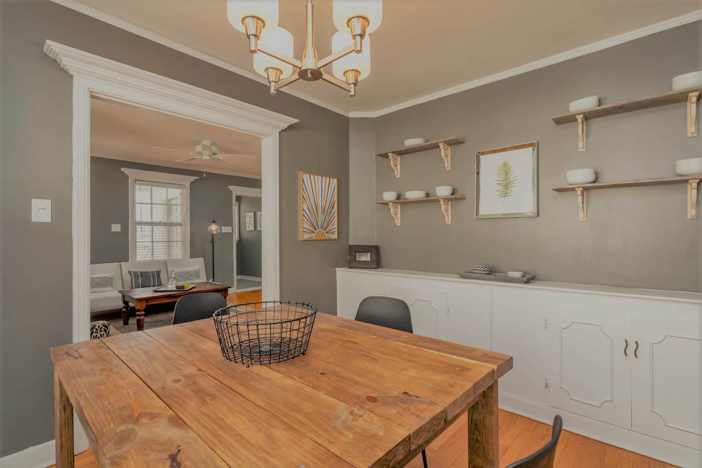 Dining room with wooden table, gray walls, and white built-in storage.