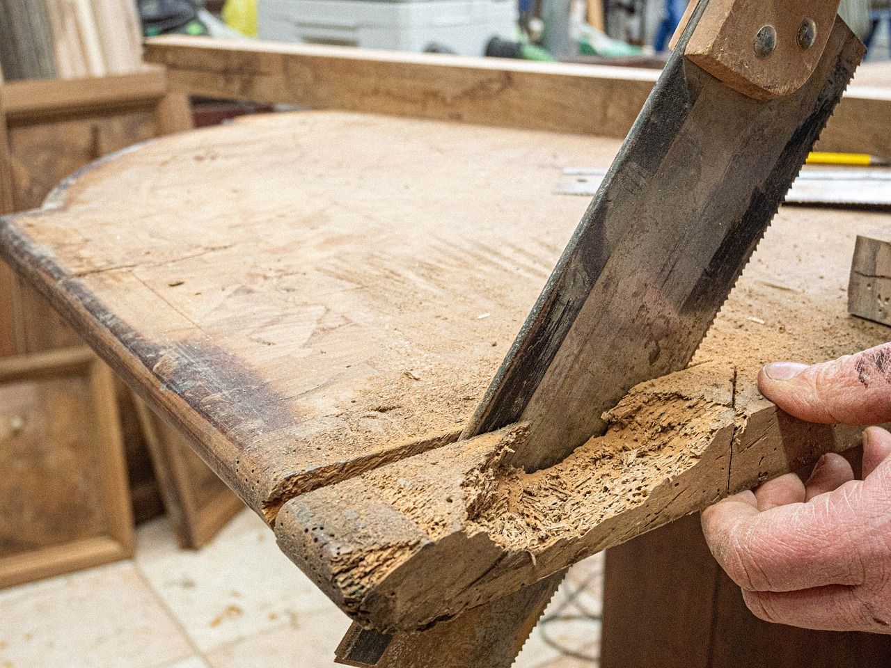 A person is cutting a piece of wood with a saw.
