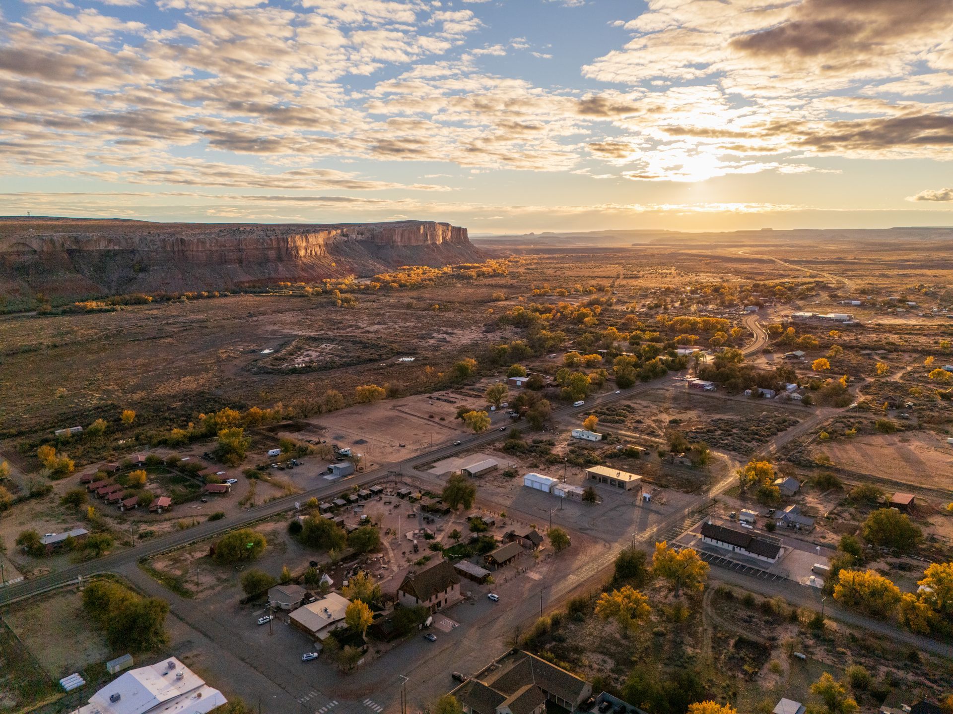 An aerial view of a small town in the desert at sunset.
