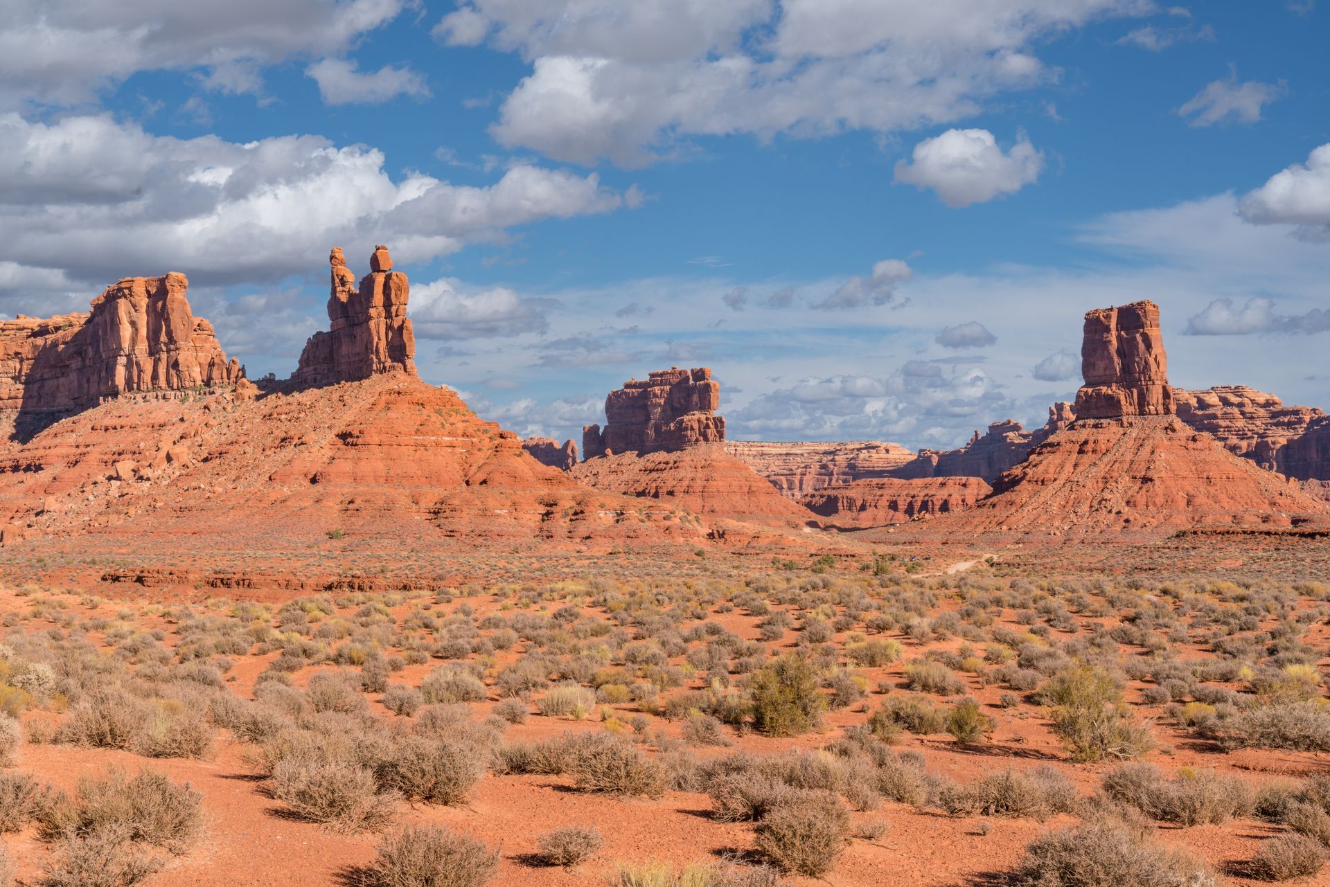 A desert landscape with rock formations in the background