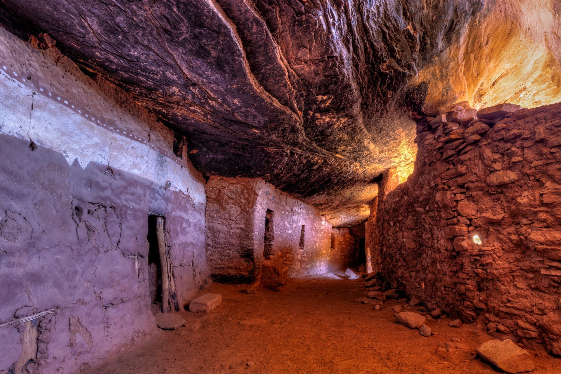 A cave with a ceiling that is covered in rocks.