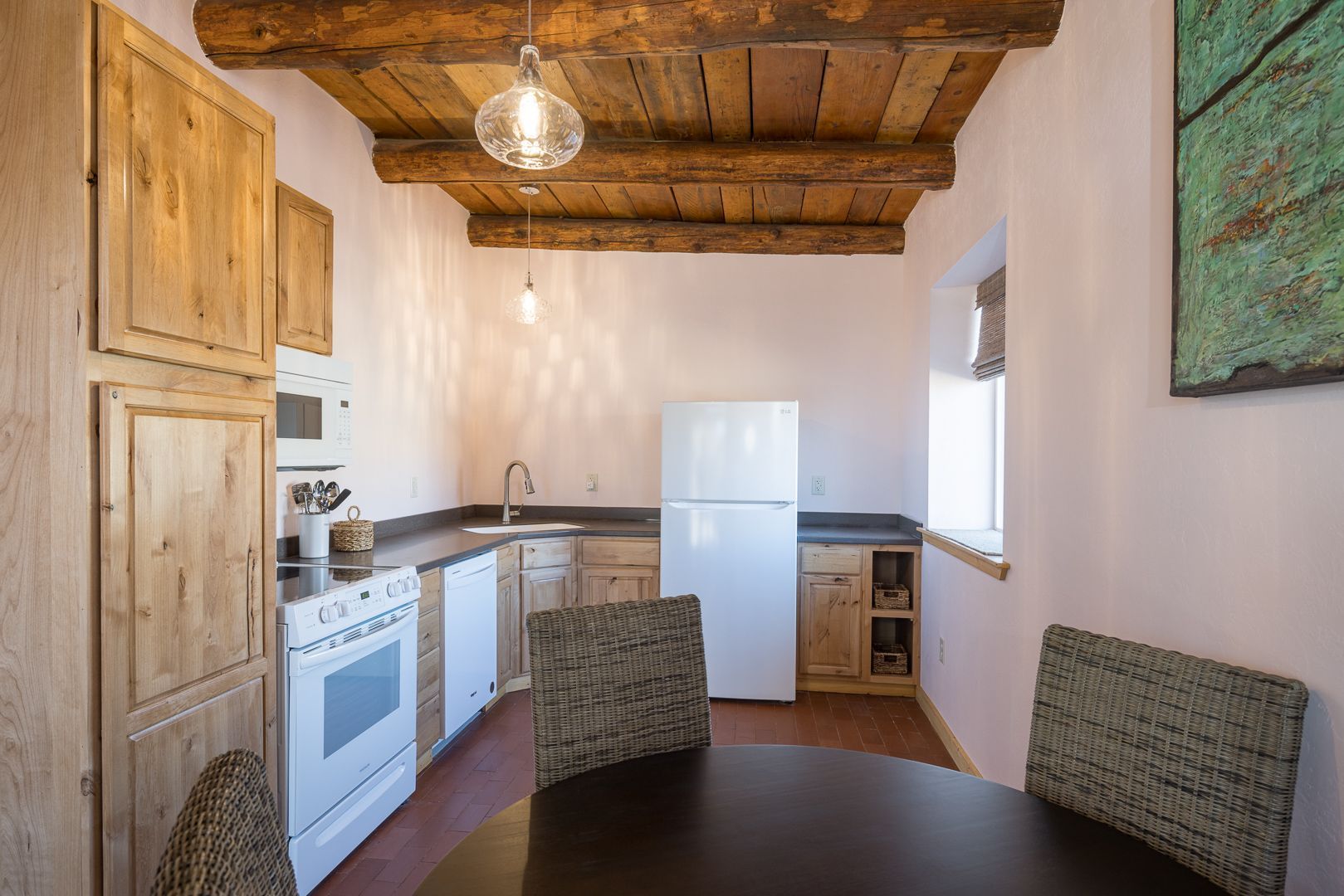 A kitchen with a table and chairs and a refrigerator.