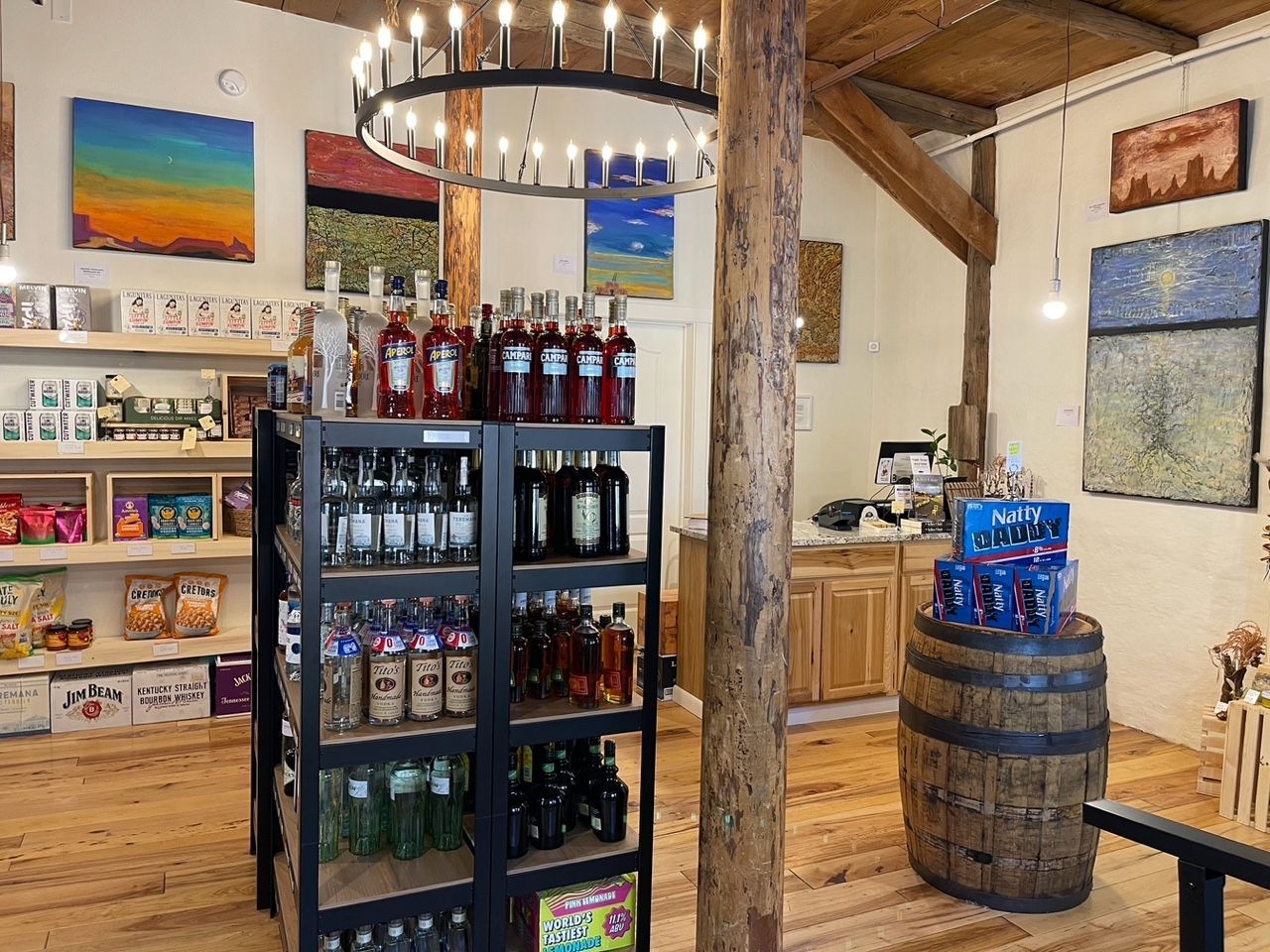 Market interior with shelves of bottles, a chandelier, and wooden decor