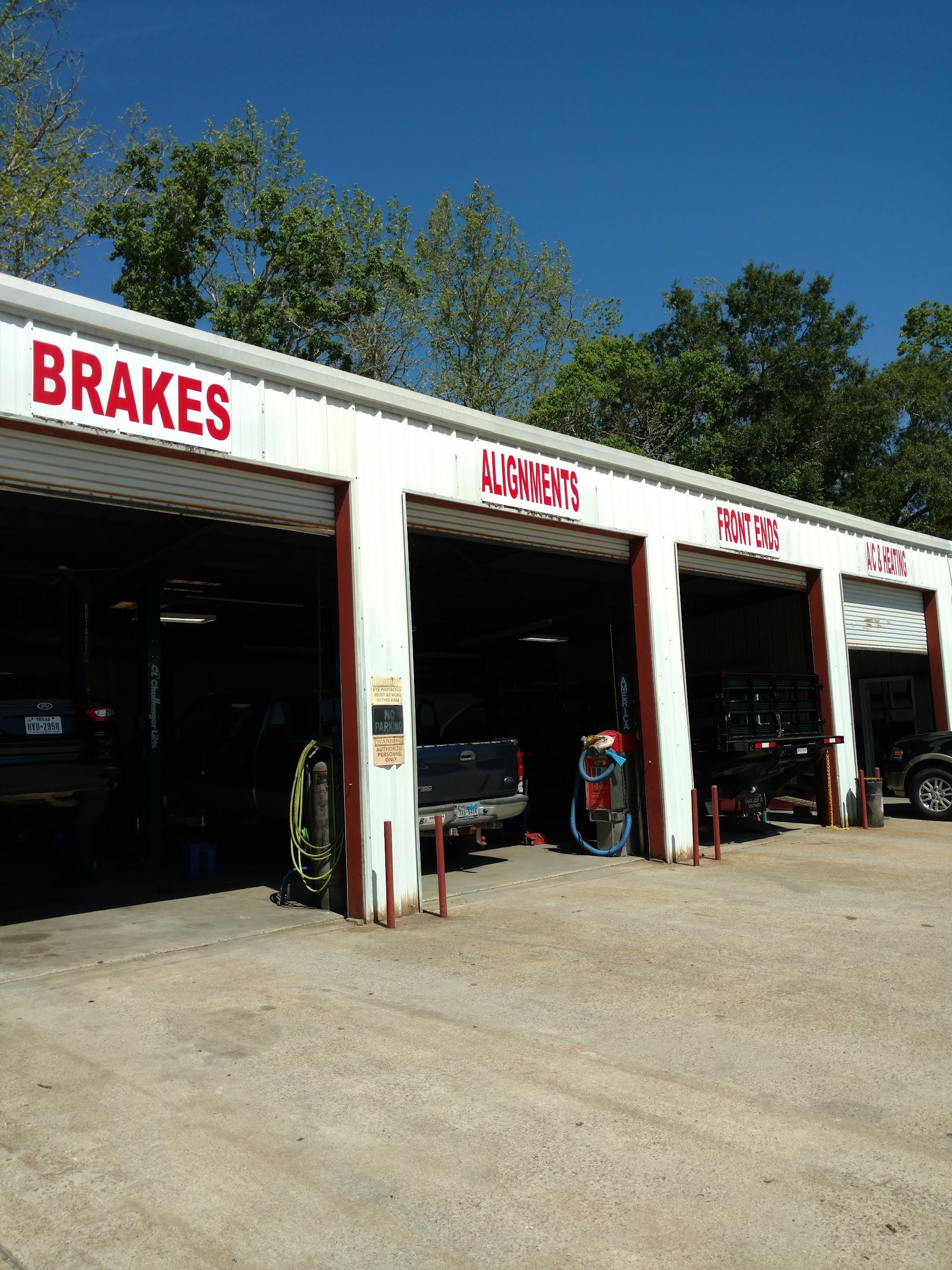 Exterior of a car repair shop with open bays;