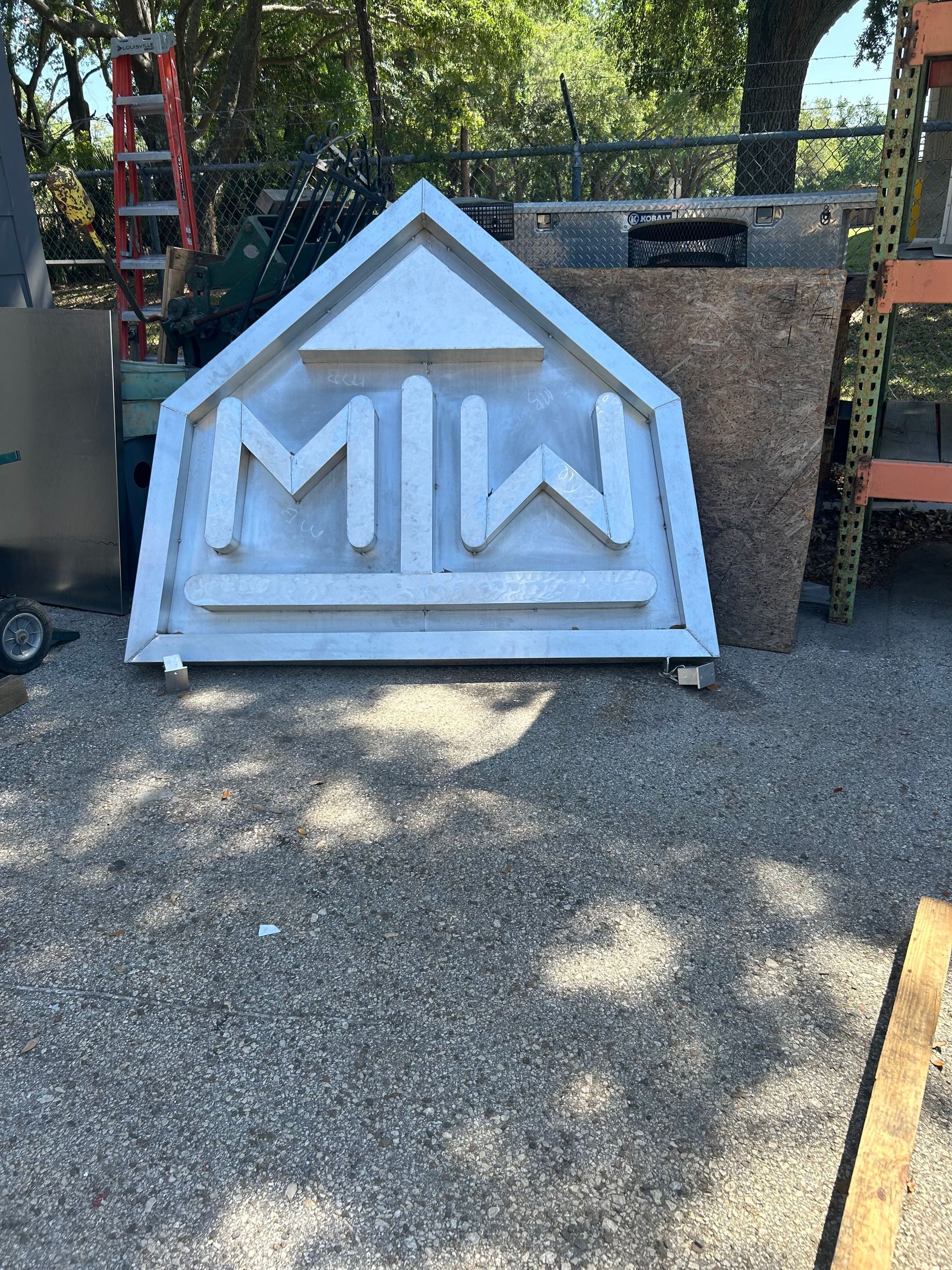 White, metal sign shaped like a house, with 
