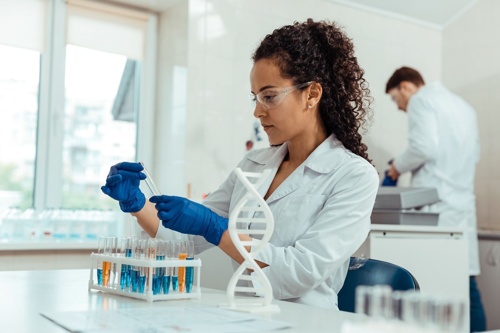 Uma cientista está trabalhando em um modelo de DNA em um laboratório.