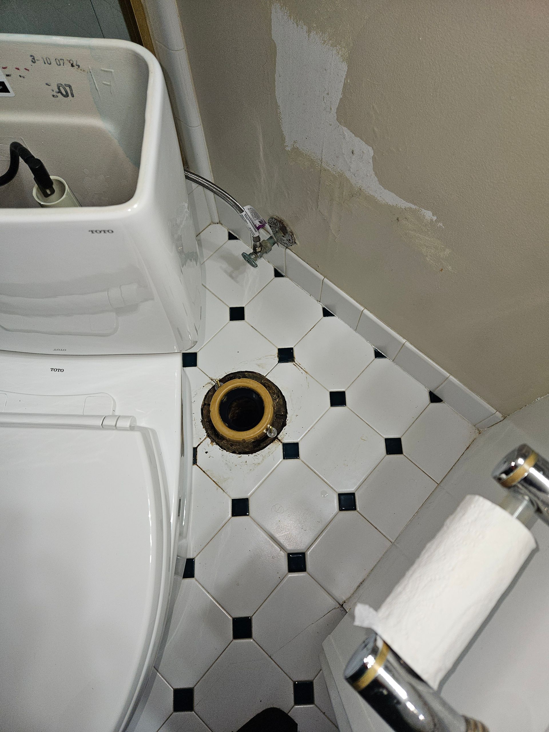 A toilet in a bathroom with a hole in the floor