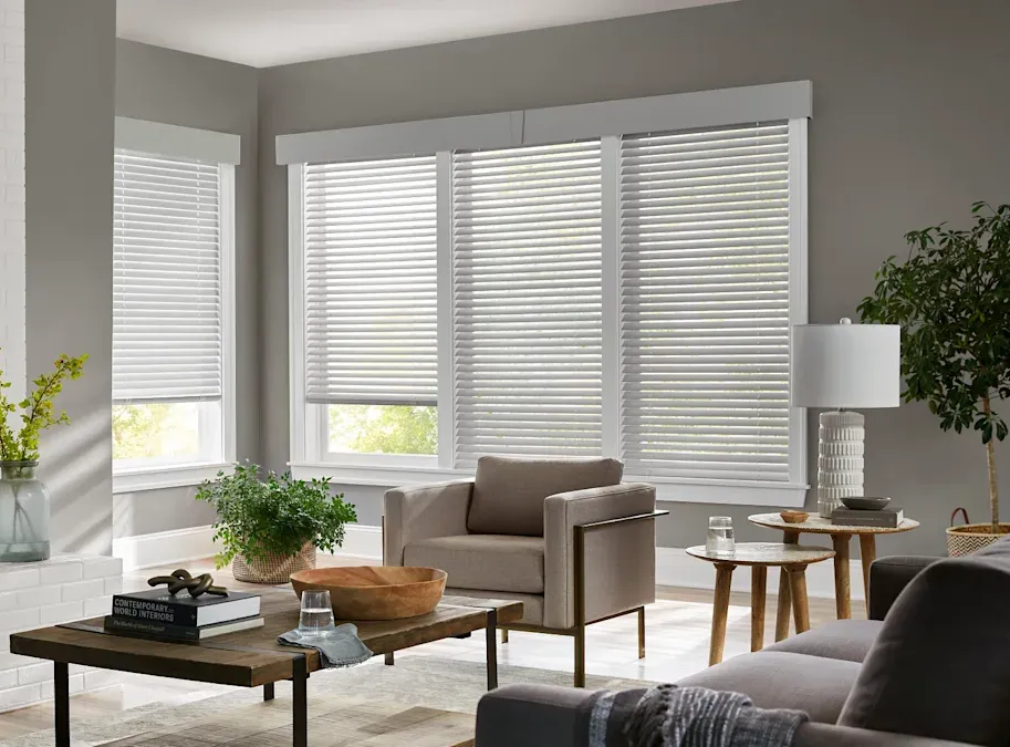Posh living room with comfortable seating, coffee table, and  multiple sets of custom blinds.