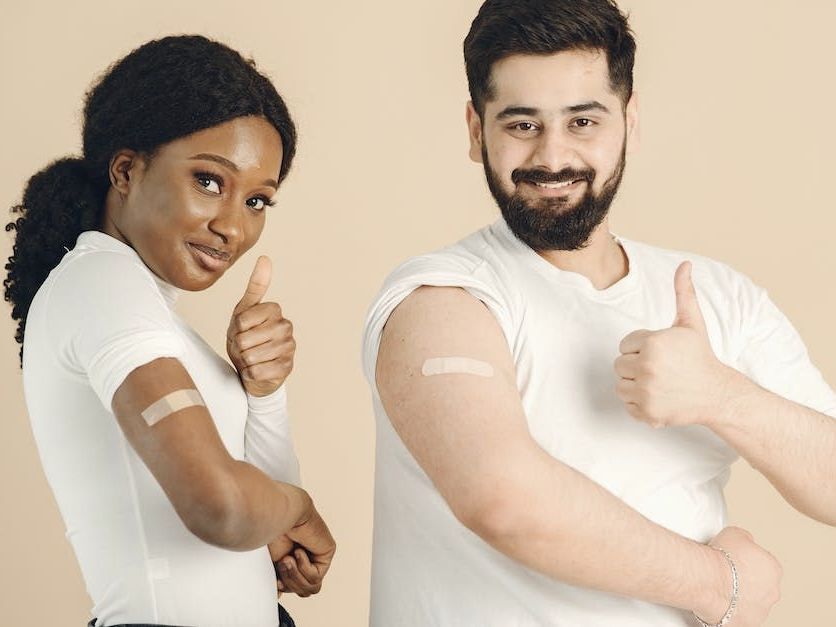Man and Woman with Plaster on Their Arms Man and Woman with Plaster on Their Arms